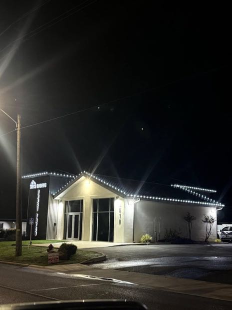 Commercial building outlined in warm white holiday lights