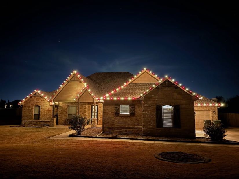Home with warm white lights running the full length of the roofline