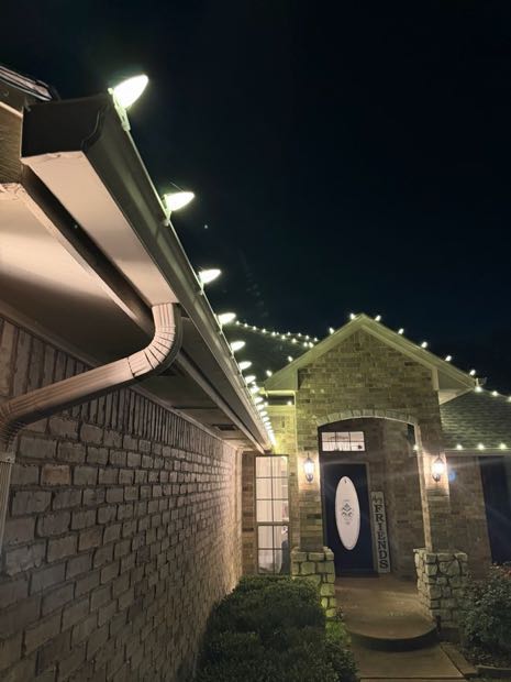 Close-up of C9 bulbs clipped evenly along a gutter line